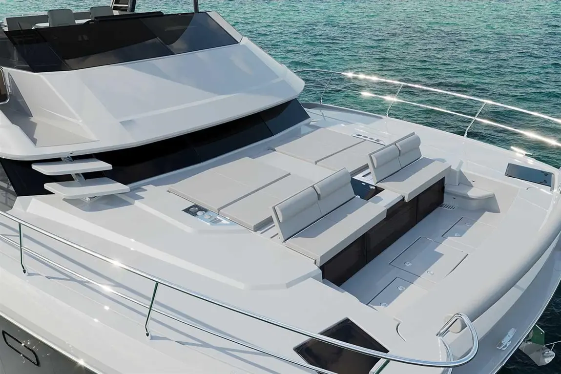Luxury yacht deck featuring upholstered seating and sleek design against a sparkling turquoise water backdrop.
